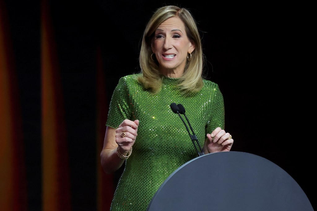 Cathy Engelbert at a podium in a green dress
